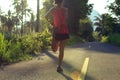 Woman runner stretching legs before running at morning tropical forest trail Royalty Free Stock Photo