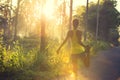 Woman runner warming up on sunrise forest trail Royalty Free Stock Photo