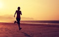 woman running on sunrise sandy beach