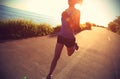Young fitness woman running on sunrise seaside trail Royalty Free Stock Photo