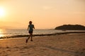 young fitness woman running at sunset beach Royalty Free Stock Photo