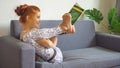 young fitness woman in sportswear doing yoga stretching leg while reading book on sofa in living room at home . sport gilr Royalty Free Stock Photo