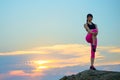 Young Fitness Woman Stretching on the Top of Rock. Female Runner Doing Stretches . Healthy Lifestyle Concept.