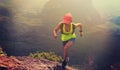 Fitness woman trail runner running up to mountain top Royalty Free Stock Photo
