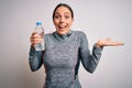 Young fitness woman wearing sport workout clothes drinking water from plastic bottle very happy and excited, winner expression