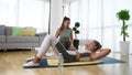 Young fitness and yoga instructor working in your home. Sporty educated woman helping young girl at her apartment at in home worko