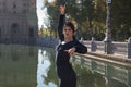 Young flamenco woman, Hispanic and brunette, with typical flamenco dance suit in black color and with tail, dancing with sun rays Royalty Free Stock Photo