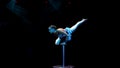 Young flexible acrobat girl doing equilibre balance on a cube in circus