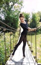 Young flexible ballerina dancing on a bridge