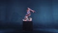 Young flexible blonde circus acrobat posing in studio in costume. Doing equilibre balance handstand on a cube.