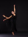 Young and flexible dancer stand in classical pose arabesque. On a black background. Royalty Free Stock Photo