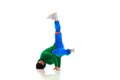 Young flexible sportive man dancing freestyle dance in green and blue sport uniform against white studio background.