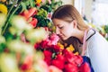 Young florist smelling beautiful fresh flowers in a flower shop. Royalty Free Stock Photo