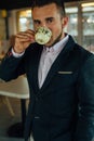 Young focused businessman drinking coffee in cafÃÂ©. Indoor photo