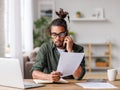 Young focused busy man entrepreneur making call via smartphone while working remotely from home Royalty Free Stock Photo