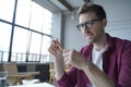 Young focused german man in glasses holding pencil sitting at desk and giving online web lesson