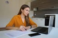 Young focused woman working filling out documents from home
