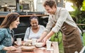 Young Food truck owner serving meal to customers table - Happy multiracial females having fun lunching