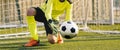 Young Football Goalkeeper Catching Soccer Ball. Soccer Goalie in Action Saving Ball in a Goal