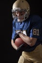 Young football player in running action close up on a dark background Royalty Free Stock Photo