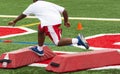 Young football player tripping over training barriers at summer camp