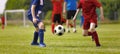 Young Football Players Kicking Ball on Soccer Field. Soccer Horizontal Background. Youth Junior Athletes in Red and Blue Soccer Royalty Free Stock Photo