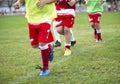 Young football players run in red and white shirts