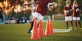 Young football players training on pitch. Soccer slalom cone drill.