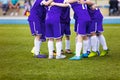 Young football soccer players in dark blue sportswear. Young sports team