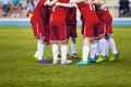 Young football soccer players in red sportswear. Young sports team. Football match for kids