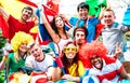 Young football supporter fans cheering with international flags at soccer match - Happy people with multicolored tshirts Royalty Free Stock Photo