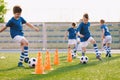 Young footballer improving dribbling skills on turf football training pitch