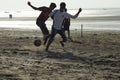 Young Footballers and athletes playing football on beach