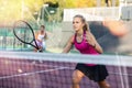 Young forcefully teenage girl playing tennis close to net on court Royalty Free Stock Photo