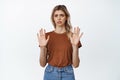 Young freak out woman raising empty hands, refusing something, rejecting offer and saying no, standing in t-shirt and Royalty Free Stock Photo