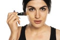 Young freckled woman applying liquid foundation with makeup brush Royalty Free Stock Photo