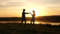 Young free couple dancing at sunset on beach. Happy guy and girl waltz in evening in a summer park. Enamored man and Royalty Free Stock Photo