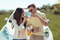 Young and free couple having little picnic near their car Royalty Free Stock Photo