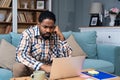 Young freelance business man or exchange student working remotely from his home office on laptop computer, having issue with Royalty Free Stock Photo