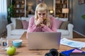 Young freelance business woman working at home on laptop as product strategy expert. Female expatriate remote work on internet on Royalty Free Stock Photo