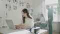 Young freelance copywriter types on laptop keyboard in room