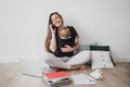 Mother working at home with baby in ergo backpack