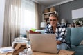 Young freelance woman working from home on laptop computer on new project for clients. Female business owner browsing the internet Royalty Free Stock Photo