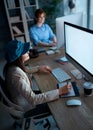 Young freelance woman working overtime with graphic tablet in of