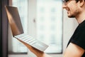 Young freelancer is holding up a thin elegant notebook