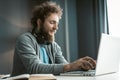 Young freelancer man working at laptop sitting at the desk at home office and making notes or programming as IT Royalty Free Stock Photo