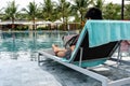 Young freelancer using laptop at swimming pool in the summer Royalty Free Stock Photo