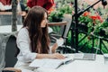 Young freelancer woman using laptop computer sitting at cafe table. Smiling woman working online or studying and Royalty Free Stock Photo