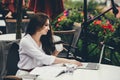 Young freelancer woman using laptop computer sitting at cafe table. Smiling woman working online or studying and Royalty Free Stock Photo