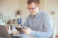 Young freelancer working with laptop at home